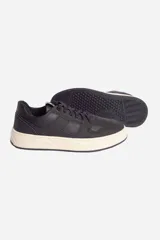 Zapatillas urbanas de cuero negro con suela de goma color crema y cordones negros. Presentan logo en etiqueta de cuero en el lateral.