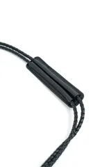 Cartera de mano negra con flecos largos colgantes y correa delgada.