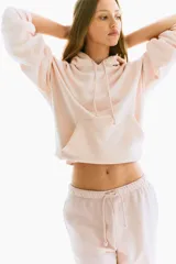 Pantalón jogger de felpa color rosa pálido, con cintura elástica ajustable con cordón, corte holgado, bolsillos laterales y piernas amplias.