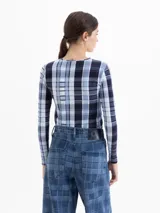 Remera de manga larga con cuello redondo, confeccionada en tela de punto con estampado de cuadros y flores. Presenta un ajuste al cuerpo.