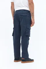 Pantalón cargo color beige con cintura clásica, bolsillos laterales con solapa y cierre de botón, y pasacintos. Diseño recto sin puños, confeccionado en algodón.