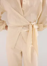 Jeans tiro medio color beige, de corte recto y holgado, con diseño clásico de cinco bolsillos y trabillas para cinturón.