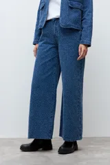 Pantalón de jean de corte recto y tiro alto, confeccionado en denim azul con una textura sutil de pequeños puntos en relieve.