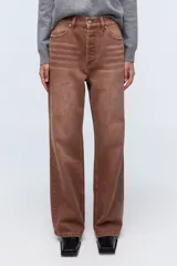 Jean marrón de tiro alto, con pierna levemente acampanada y cierre con botones metálicos.