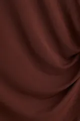 Top marrón de punto suave con mangas japonesas, corte entallado, cuello redondo y frunces laterales que crean un efecto drapeado.