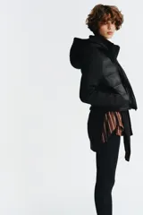 Chaqueta acolchada negra con cuello subido y capucha ajustable con cordones elásticos y stopper. Mangas largas combinadas en tejido efecto neopreno. Bolsillos laterales y cierre frontal con cremallera termosellada.