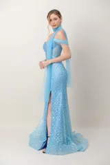 Vestido largo de fiesta en tul bordado con lentejuelas celestes, silueta ceñida, escote con tirantes caídos y tajo frontal.