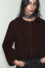 Chaqueta bomber de cuello redondo y manga larga con acabado elástico en puños y ruedo. Presenta cierre frontal con cremallera y bolsillos delanteros de vivo.