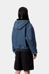 Campera de jean con capucha, forrada en su interior con tejido tipo corderito negro. Presenta cierre frontal, bolsillos tipo canguro y puños y ruedo de rib elástico. Incluye etiqueta de la marca en el bolsillo frontal.
