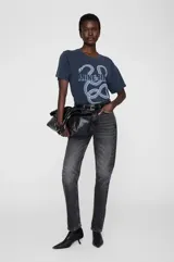 Remera de algodón con efecto lavado, cuello redondo y calce holgado. Presenta un estampado gráfico frontal con una serpiente y el logo de la marca.