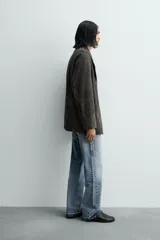 Blazer relaxed fit de piel con acabado ante, color gris oscuro. Cuello con solapas de muesca, manga larga, bolsillo de plastrón con solapa en el pecho y dos bolsillos de plastrón en la cadera. Cierre frontal de botonadura con botones claros.