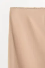 Falda mini de tiro bajo, confeccionada en tejido liso de color negro, con diseño minimalista y cintura elástica.