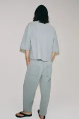 Pantalón de tiro medio confeccionado en hilatura con mezcla de algodón, con diseño de rayas diplomáticas. Presenta bolsillos laterales ocultos en costura, pierna ancha y cierre frontal con cremallera y botón.