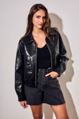 Campera bomber de cuero sintético negro, de corte oversize, con cuello solapa, cierre frontal metálico y bolsillos frontales con solapa.