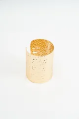 Brazalete rígido de metal dorado con textura martillada y diseño abierto.