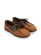 Mocasines tipo náutico de cuero color marrón tostado, con detalles en cuero marrón oscuro en el cuello y cordones decorativos. Presenta costuras reforzadas en la puntera y suela plana de goma.