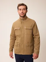 Campera estilo cargo de color tostado, con cuello alto, cierre frontal oculto por solapa y cuatro bolsillos frontales con solapa y botones a presión.