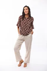 Blusa marrón con estampado floral blanco, de mangas cortas acampanadas y corte holgado.