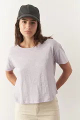 Remera de algodón de manga corta y cuello a la base en color lila claro, con diseño de corte recto y holgado.