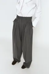 Pantalón de tiro medio con pinzas frontales, confeccionado en tejido con viscosa. Presenta cintura con trabillas, bolsillos laterales y cierre frontal con cremallera, botón y ganchos metálicos.