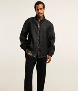 Pantalón de sastrería negro de corte recto, con trabillas, elástico trasero en la cintura, bolsillos laterales y cierre tradicional.