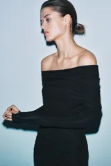 Vestido largo negro de manga larga confeccionado en mezcla de viscosa. Presenta cuello amplio multiposición y detalle de drapeado fruncido en el lateral del torso.