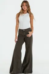 Jean de corte flare y tiro bajo, color verde oliva con costuras frontales verticales y ruedo desflecado.