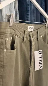 Pantalón de jean verde con corte recto y diseño de costuras diagonales en la parte delantera.