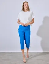 Pantalón capri de gabardina elastizada color celeste, con bolsillos simulados delanteros y bolsillos aplicados traseros. Tiene pretina ancha, corte recto y detalle calado en el ruedo.