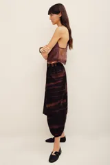 Pantalón babucha de algodón con estampa batik en tonos marrones y negros, tiro bajo y diseño amplio con puños elastizados en los tobillos.