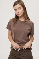 Remera de manga corta y cuello redondo color gris con efecto lavado, calce relajado y detalles de strass aplicados en la parte superior.
