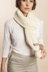 Bufanda tejida a mano en punto arroz color crudo, con detalle de pompón en uno de los extremos.