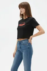 Remera cropped de algodón negra con cuello a la base, mangas cortas y estampado frontal de cerezas con la palabra "HELLO".