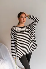Buzo de viscosa de corte holgado, con diseño a rayas horizontales en blanco y negro, escote bote y mangas largas caídas.