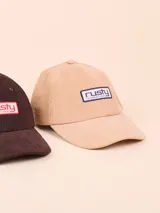 Gorro de pana color beige con visera curva y logo de la marca bordado en el frente.