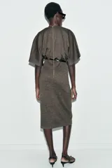 Vestido midi de escote en pico cruzado y manga corta. Presenta detalle de frunces en la cintura y un cinturón integrado con hebilla metálica a contraste.