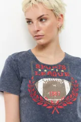 Remera negra de manga corta con estampa de escudo con la inscripción "Sports League" y una pelota de fútbol americano.