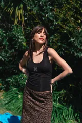 Musculosa de viscosa color blanco, de corte ajustado y diseño acanalado, con un pequeño estampado negro en el centro del pecho.