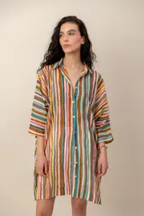 Vestido corto camisero con estampado de rayas multicolores, cuello camisero, mangas tres cuartos y cierre frontal de botones.