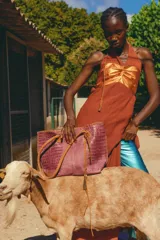 Vestido largo con pechera de cuero metalizado y falda tejida con hilo de lurex brillante. Presenta un diseño de cuello halter y corte fluido.