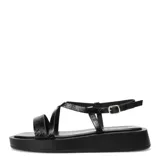 Sandalias plateadas con tiras cruzadas y plataforma plana negra.