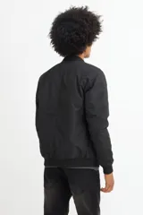 Campera bomber negra de poliéster con cierre frontal y cuello redondo.