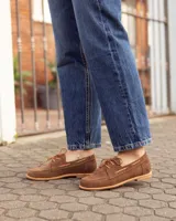 Mocasines estilo náutico de cuero color marrón, con cordones y costuras pespunteadas en el empeine.