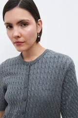 Cardigan gris melange de tejido de punto con diseño texturizado, manga corta y cierre frontal con botones.