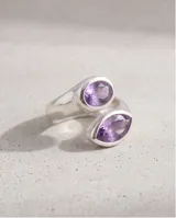 Anillo de plata 925 con diseño cruzado y piedra amatista en forma ovalada.