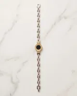 Pulsera de plata y lámina de oro 18k, con eslabones de cadena y un dije central redondo con piedra ónix negra y diseño de guarda griega.