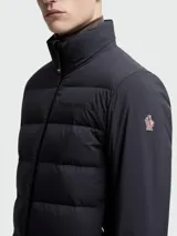 Campera puffer Moncler modelo Agaripe en color azul marino, diseñada con un cuerpo acolchado y mangas de tejido técnico. Incluye cuello alto, cierre frontal de cremallera, puños con orificios para el pulgar y aislamiento PrimaLoft.