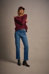 Sweater tejido color marrón claro, de escote redondo y calce holgado. Tiene hombros caídos, mangas largas y puños tejidos.