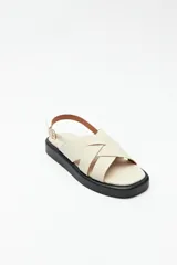 Sandalias color beige con capellada entrelazada y agarre ajustable en el talón. Plataforma de 3cm de alto y suela negra.