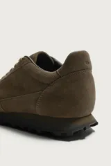 Zapatilla de cordones estilo running, confeccionada en piel con acabado en serraje color marrón. Cuenta con detalles de pespuntes y suela dentada a contraste de color negro.